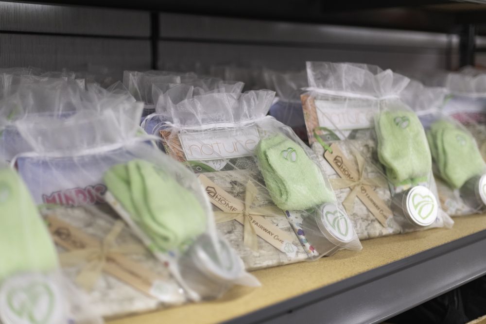 A shelf of hand-assembled Fairway Cares comfort gift bags with fuzzy socks and coloring books