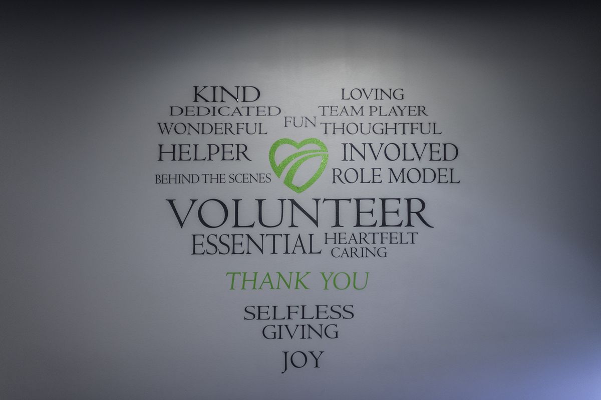A wall in the Fairway Cares office with words arranged in a heart shape: kind, dedicated, volunteer, selfless, giving, joy, thank you
